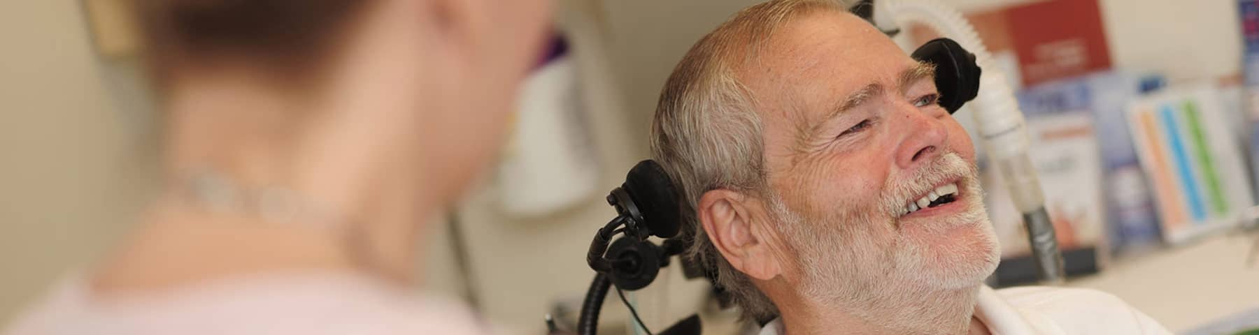 Christopher Pendergast sitting and smiling at the ALS Center of Excellence