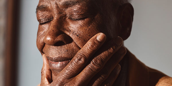 A man with his hand around his chin thinking deeply.