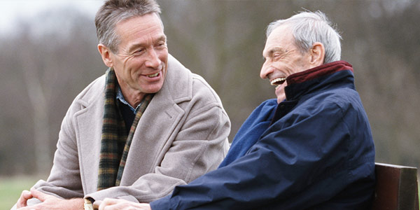 Two elderly men at a park discussing Parkinson's Disease